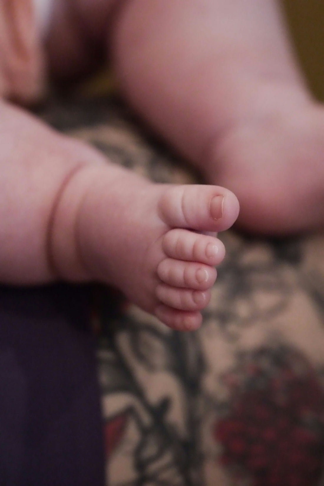 A close up of a baby's foot on a bed